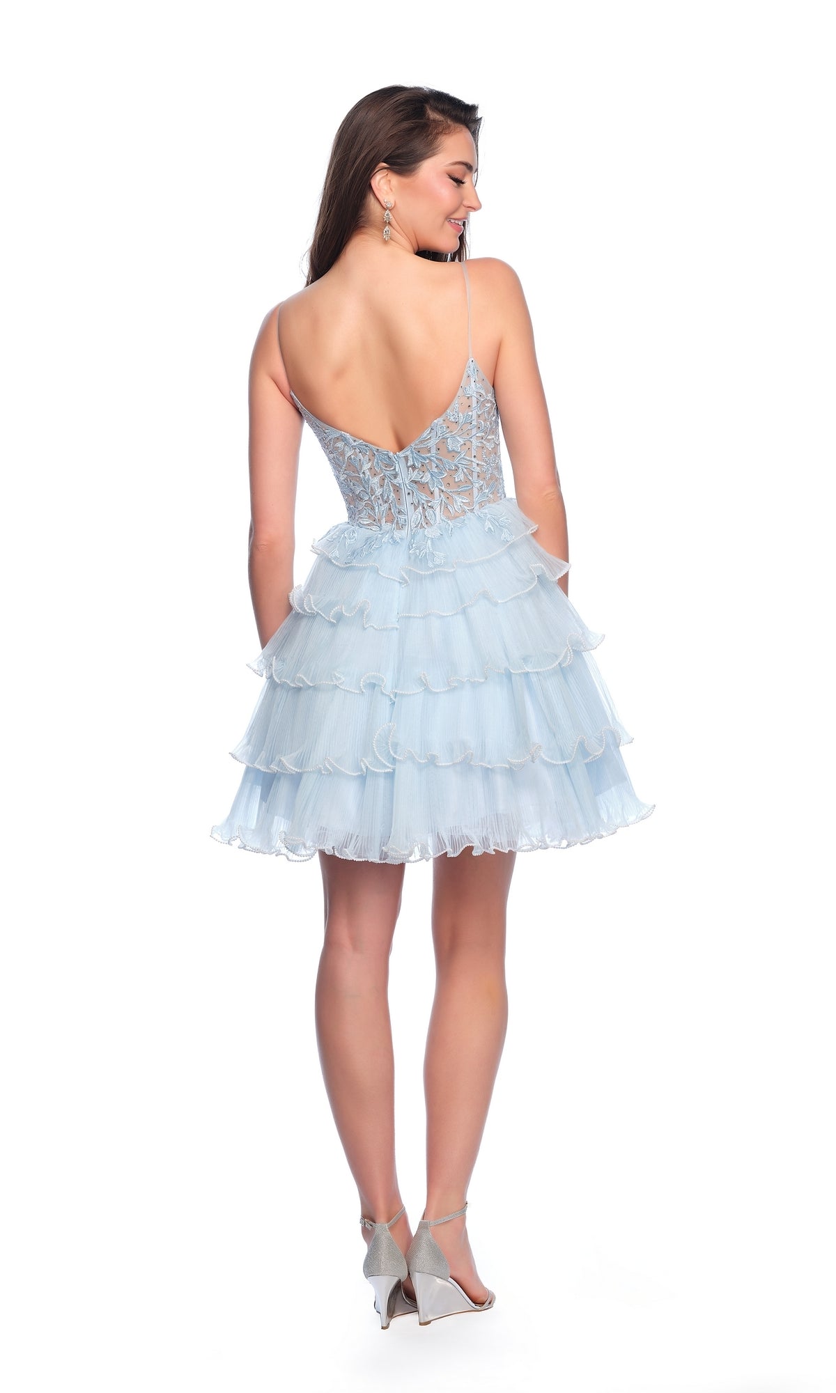 Woman in a Dave and Johnny Short Blue A-Line Hoco Dress 11753 with a backless lace bodice and tiered ruffled skirt, standing and facing away on a white background.